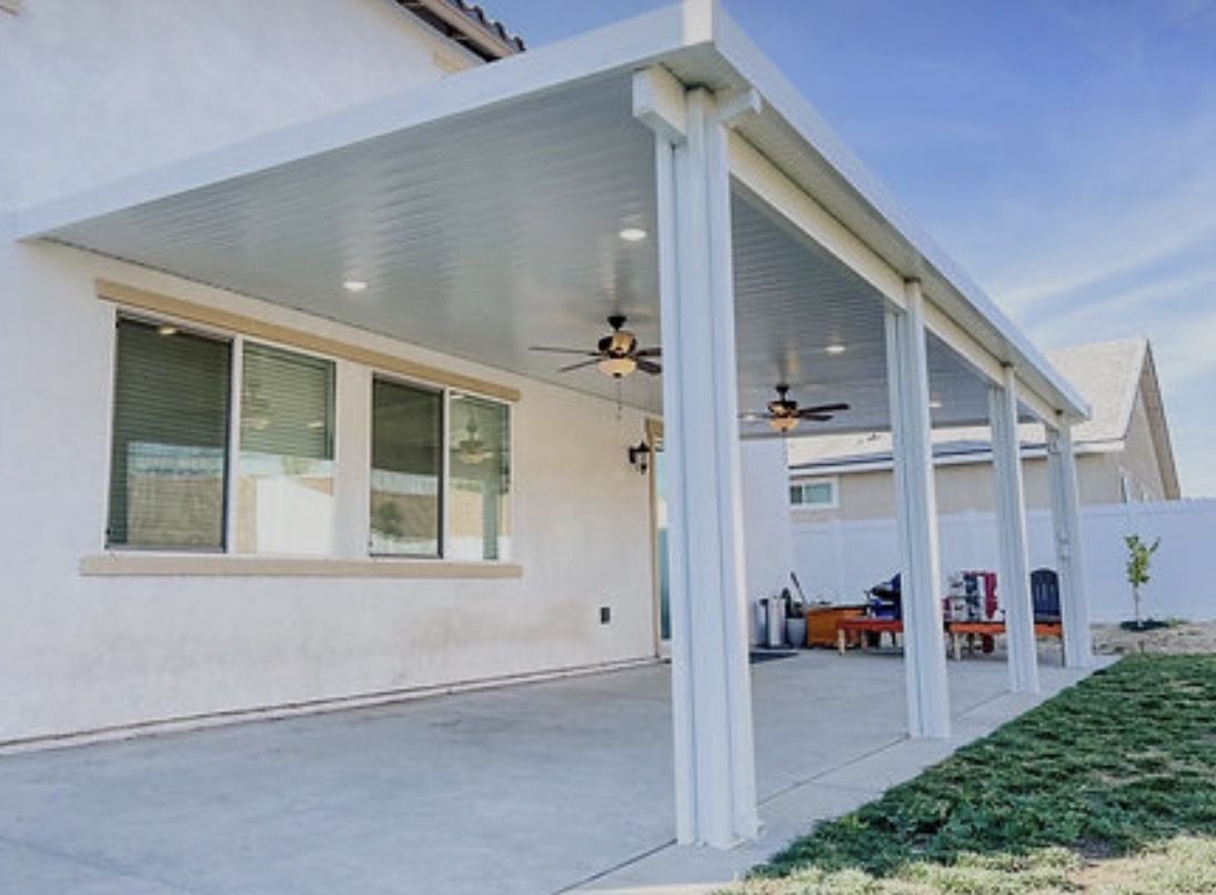 White aluminum patio cover with ceiling fans on a stucco home