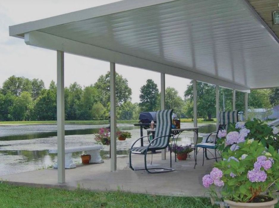 White aluminum patio cover over a patio by a pond