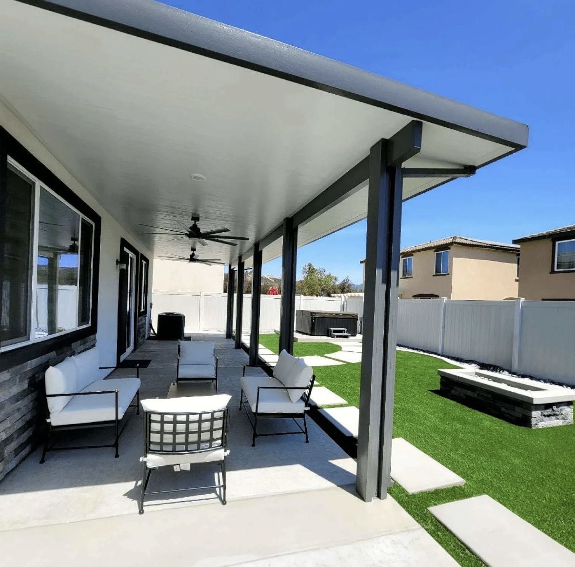 Dark-framed aluminum patio cover over patio furniture