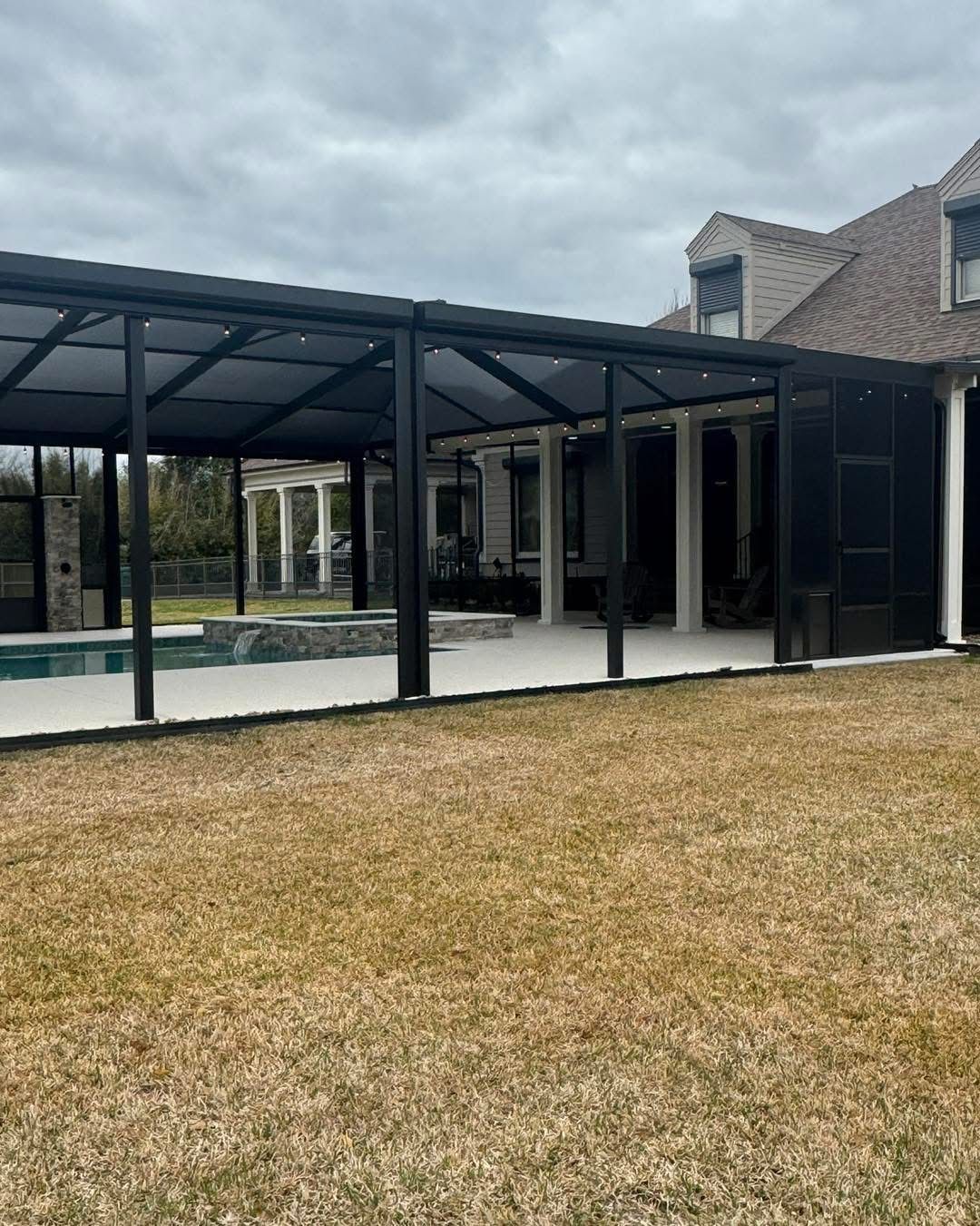 Long black-framed pavilion cover beside a pool