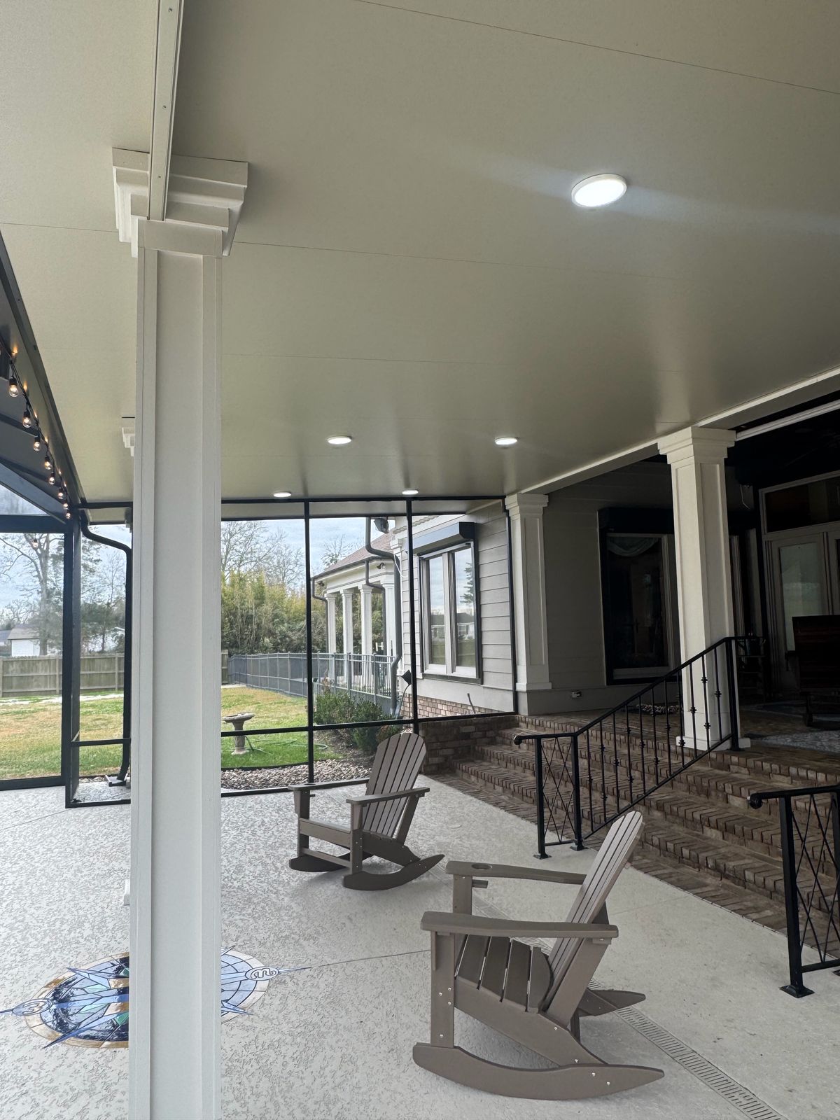 Covered patio with white columns, recessed lights and brick steps
