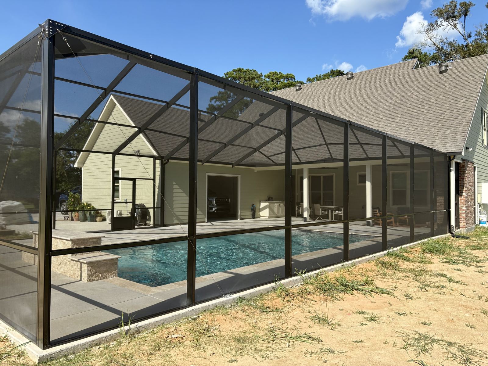 Long screened pool enclosure along the back of a home