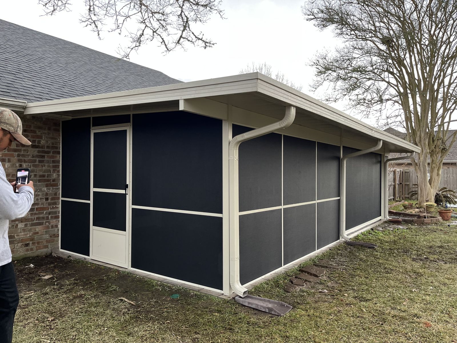 Screen room with screen door and kick panels on a brick home