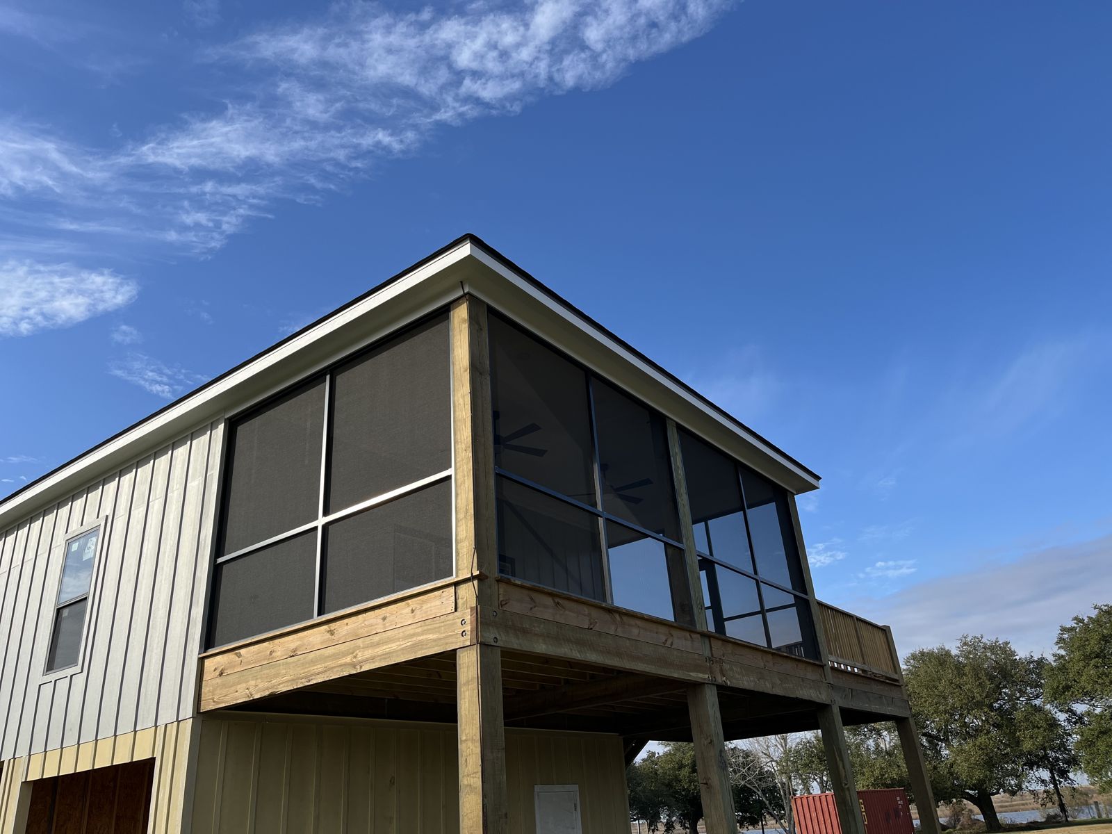 Screened second-story porch on a board-and-batten home