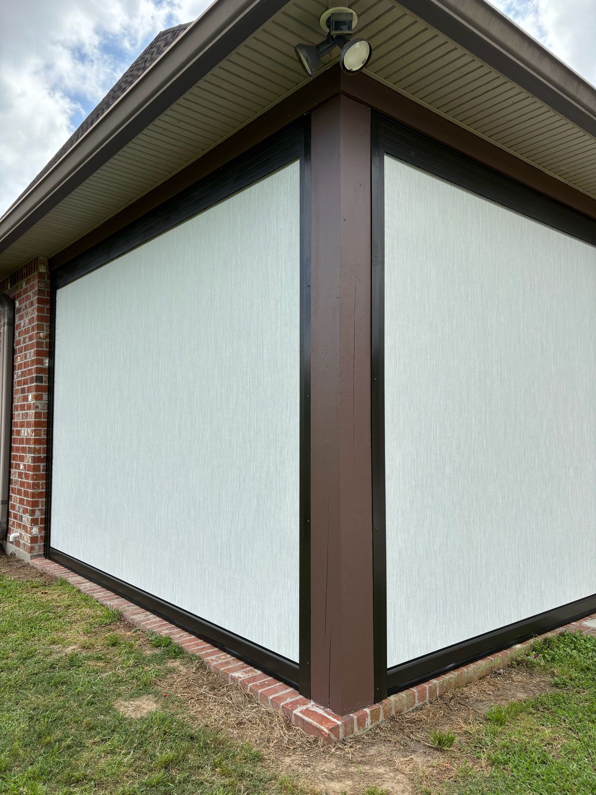 Light roller shades wrapping the corner of a covered patio