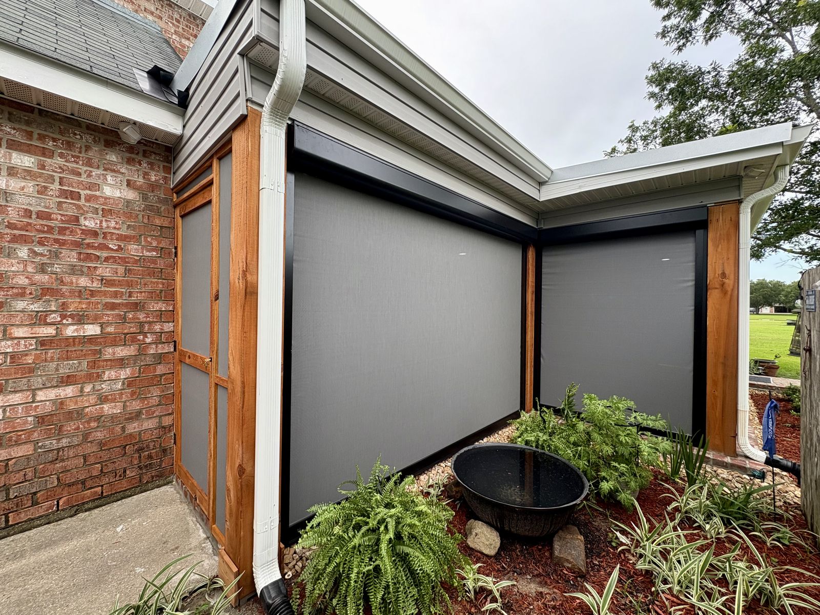 Gray shades on an L-shaped patio corner with a wood-framed door