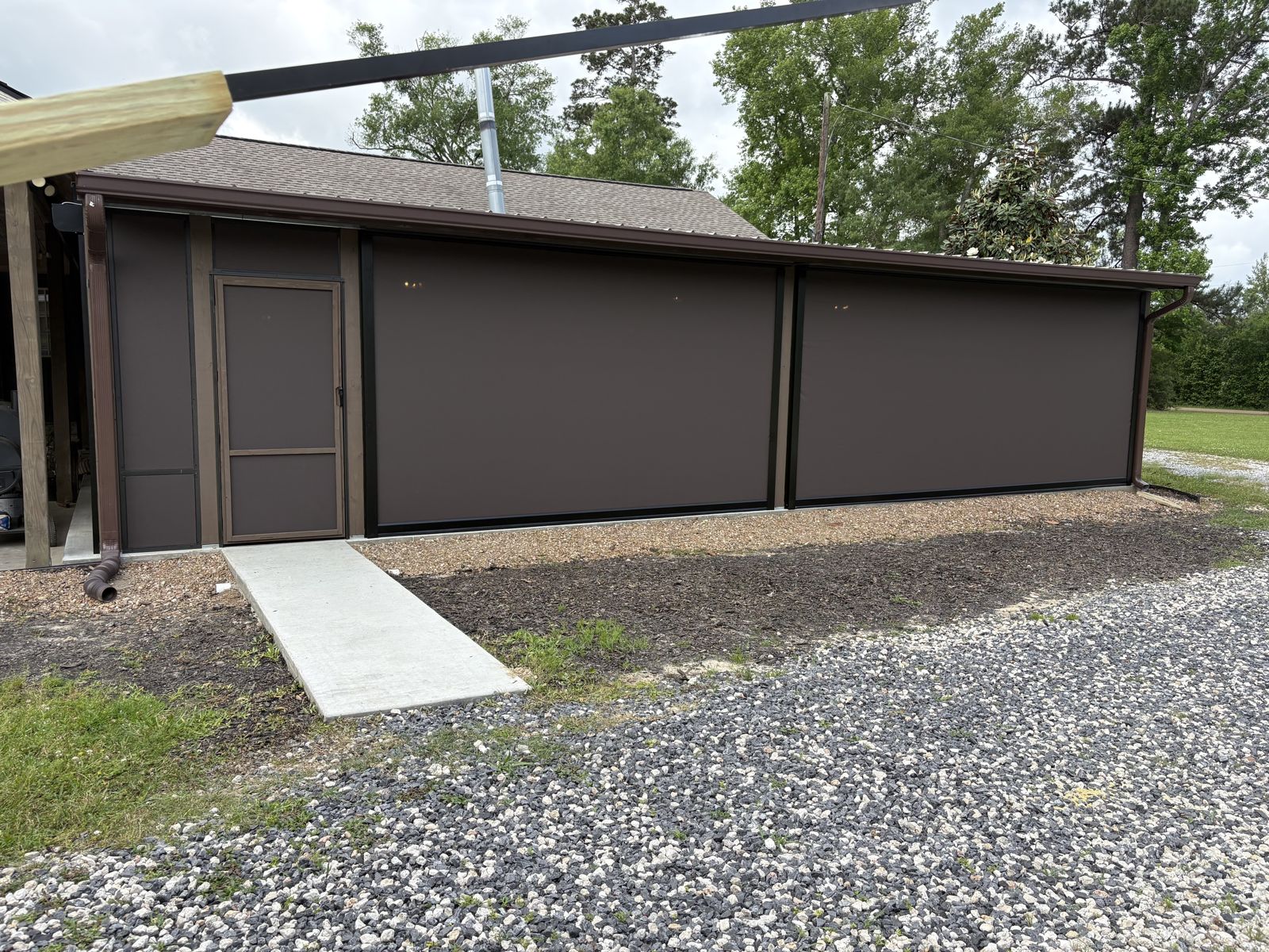 Large brown shade panels with a wood door on an outbuilding
